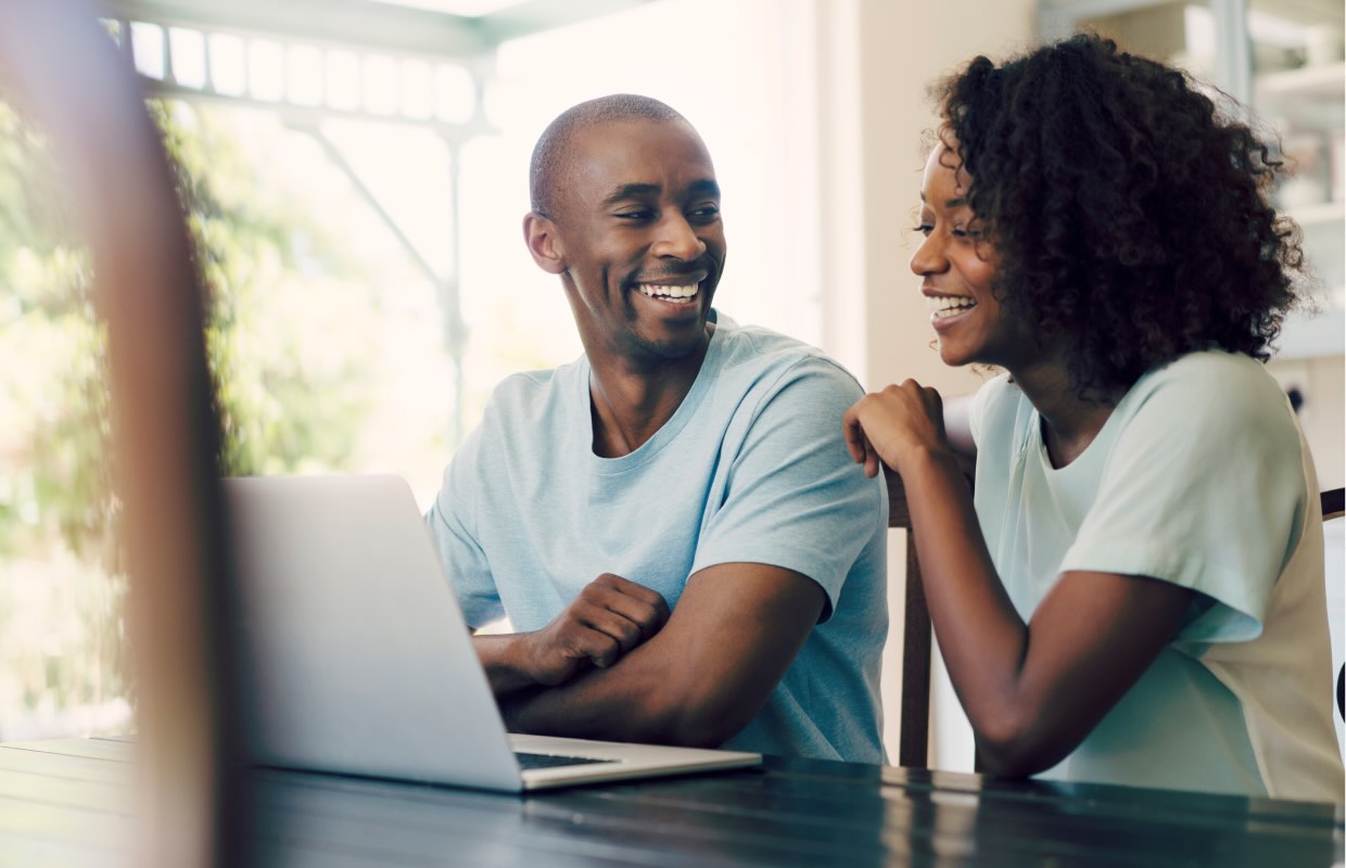 30s black couple look at computer together